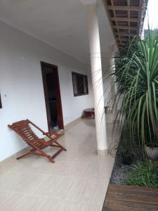 a room with a bench and a palm plant at Vila do Aconchego in Ubatuba