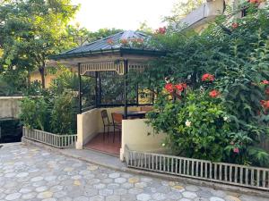 a gazebo with a table and some flowers at Nargiz's Guest House in Batumi