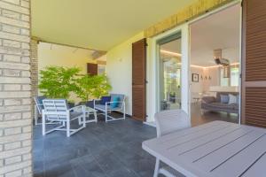 a patio with a table and chairs and a couch at Cà Stagia holiday house with private swimming-pool in Bellagio