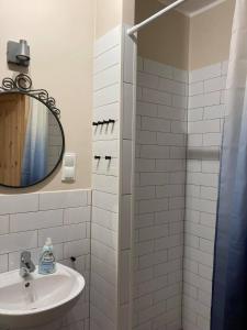 W białej łazience znajduje się umywalka i lustro. w obiekcie Maja w Łagowie