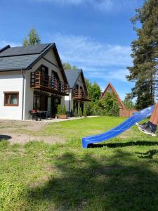 a house with a blue slide in the yard at Jarzębinowy Zakątek in Kopalino
