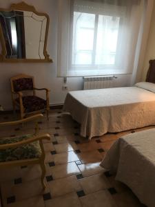 サンシェンショにあるPlaya Silgar en Galiciaのベッドルーム1室(ベッド2台、鏡、椅子付)