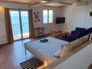 a bedroom with a bed and a living room with a view at Sea House Bassi in Kraljevica