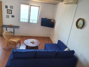 a living room with a blue couch and a table at Sea House Bassi in Kraljevica