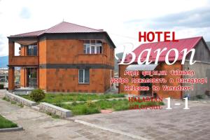 un cartello per una camera d'albergo di fronte a un edificio di Baron Hotel a Vanadzor