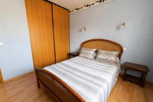 Dormitorio pequeño con cama con cabecero de madera en Chambre privée de 12m² dans une maison toute équipée, en Aureilhan