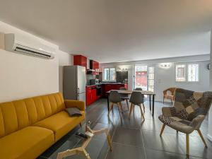 a living room with a yellow couch and a kitchen at T2 tout équipé à 2 min de la plage ménage inclus 1 in Banyuls-sur-Mer +3 photos