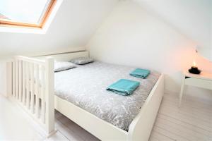 a white bedroom with a bed with two bags on it at Beautiful Terrace Apartment in the Heart of Antwerp in Antwerp