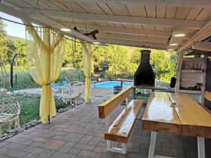 a patio with a wooden table and a wine bottle at Holiday home Melani - with private heated pool and sauna in Sinac