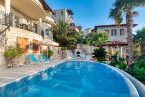 a swimming pool in front of a house at Villa Palm Kaş in Kaş