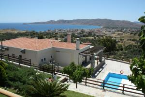 a villa with a swimming pool and a view of the ocean at Aegea Hotel in Karistos