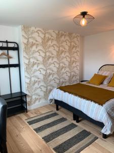 a bedroom with a bed and a wall mural at Les Remparts de Joussaume Latour in Château-Thierry