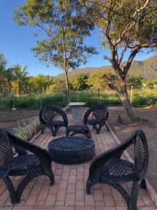 a group of benches sitting around a table with a tire at Chalés Vila Bela Vale do Capão in Vale do Capao