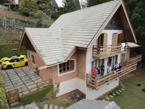 カンポス・ド・ジョルドンにあるCountry Home by Capivari Lodge Homeの家のバルコニーに立つ集団