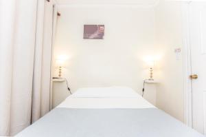 a white bed in a white room with white curtains at Hotel Amalfi - ex Santisimo in Viña del Mar +21 photos