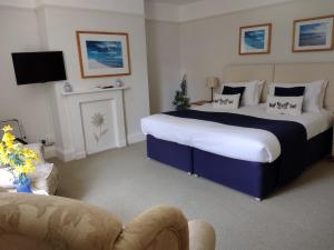 1 dormitorio con 2 camas, TV y sofá en Buckley Farmhouse en Sidmouth