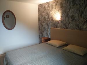 een slaapkamer met een bed met een spiegel aan de muur bij Ooldershoeve in Onstwedde