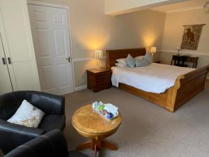 1 dormitorio con 1 cama, 1 silla y 1 mesa en Ardmore House en Clifden