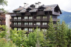 a large wooden building with trees in front of it at Courchevel 1550 – VERITABLE SKI AUX PIEDS – APPARTEMENT LES TOVETS T2 – 47m2 – 4P in Courchevel