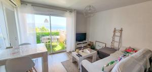 a living room with a couch and a table and a television at Appartement Ajaccio vue mer panoramique in Ajaccio