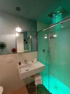 La salle de bains est pourvue d'un lavabo et d'une douche en verre. dans l'établissement B&B Giro Di Boa, à Lampedusa