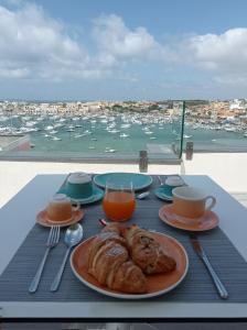 un tavolo con piatto di cibo e vista su un porto di B&B Giro Di Boa a Lampedusa