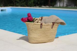 a basket of flowers sitting next to a pool at Meio Country House in Alcanede