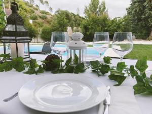una mesa con copas de vino y un plato en ella en Meio Country House en Alcanede