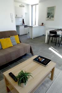 - un salon avec un canapé et une table dans l'établissement Maison Carrée/Coeur historique de Nîmes - Superbe Appt 55m², à Nîmes