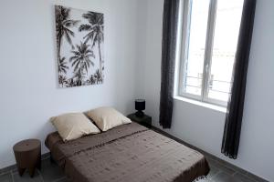 - une chambre avec un lit dans une pièce dotée d'une fenêtre dans l'établissement Maison Carrée/Coeur historique de Nîmes - Superbe Appt 55m², à Nîmes