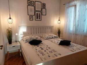 um quarto com uma cama com duas almofadas em Apartments Rako M&I em Podstrana