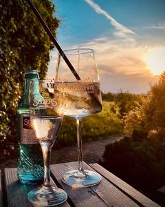 eine Flasche Wein und zwei Gläser auf dem Tisch in der Unterkunft Hainberg Hotel in Ebersbach-Neugersdorf