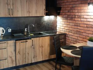 グダニスクにあるAlbatros Blueのレンガの壁、シンクとテーブル付きのキッチンが備わります。