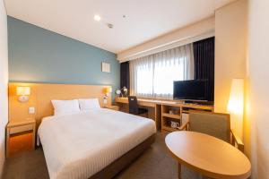 
a hotel room with two beds and a television at Art Hotel Hirosaki City in Hirosaki

