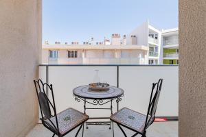 uma mesa de pátio e cadeiras numa varanda com um edifício em Studio avec balcon, plage à 50m, proche Vieux Port em Marselha