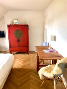een woonkamer met een tafel en een rode kast bij Alberti Bed & Bike in Maastricht
