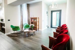 a waiting room with green chairs and a table at In Centro Luxury Rooms in Como