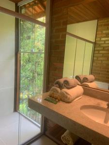 a bathroom with a sink and a mirror at Cactus Chalé em lumiar in Lumiar