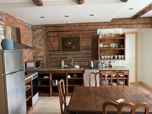 a kitchen with a brick wall and a wooden table at Haapsalu Guesthouse in Haapsalu