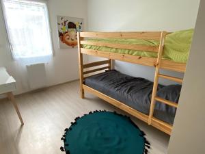 een slaapkamer met 2 stapelbedden en een tapijt bij LOGEMENT en rdc Port Haliguen in Quiberon