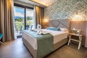 a hotel room with a bed and a balcony at VERANO LUXURY STUDIOS in Chrysi Ammoudia