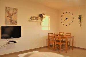 a dining room with a table and a tv on a wall at צימר מול השקיעה in Retamim