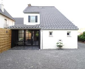 a white house with a black roof at Vakantiewoning Mèzik in Maasmechelen