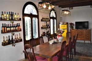 a dining room with a wooden table and some wine bottles at Maison Elena in Mirano