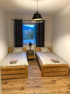 2 camas en una habitación con ventana en Apartament całoroczny Bieszczadzka Gawra, en Ustrzyki Dolne