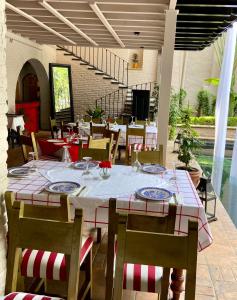uma sala de jantar com uma mesa e cadeiras, uma mesa e uma espreguiçadeira em Il Piccolo Peccato em Cuernavaca