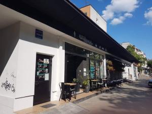 restauracja ze stołami i krzesłami poza budynkiem w obiekcie Apartament Centrum - Aleja Świętego Jana Pawła II w Kołobrzegu