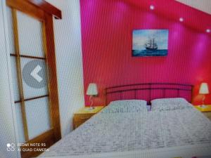 - une chambre avec un grand lit et un mur rose dans l'établissement App 1 Alen, à Crikvenica