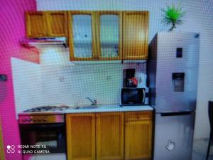 Elle comprend une petite cuisine avec des placards en bois et un réfrigérateur. dans l'établissement App 1 Alen, à Crikvenica
