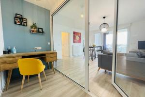a living room with a desk and a yellow chair at Bright apartment in a new building with garage in Tours